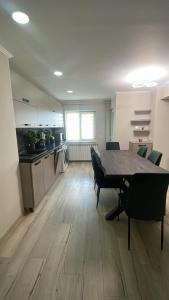 a room with a table and chairs and a kitchen at Tudor Apartament in Ocna-Mureşului