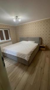 a bedroom with a bed and a wooden floor at Tudor Apartament in Ocna-Mureşului