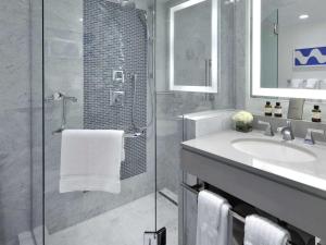 a bathroom with a shower and a sink and a mirror at Hamilton Princess & Beach Club A Fairmont Managed Hotel in Hamilton