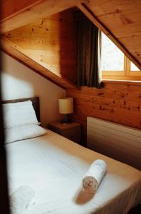 um quarto com uma cama num chalé de madeira em Auberge Restaurant du Lac Retaud em Les Diablerets