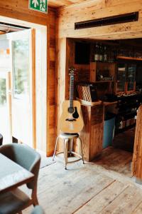 uma guitarra sentada numa cadeira numa sala em Auberge Restaurant du Lac Retaud em Les Diablerets