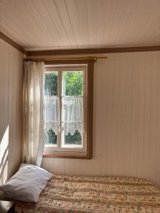 um quarto com uma cama e uma janela em Auberge du Jardin em Petit-Saguenay