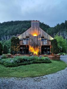 um grande celeiro de madeira sentado em cima de um campo em Auberge du Jardin em Petit-Saguenay