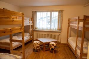 Cette chambre comprend 3 lits superposés et une fenêtre. dans l'établissement Madrisa Lodge, à Klosters