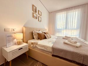 een slaapkamer met een groot bed en een raam bij M&E Premium Apartments - San Pietro in Durrës