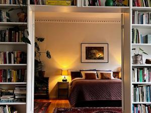 um quarto com uma cama num quarto com prateleiras de livros em Spacious historical art oasis in the city center em Bergen