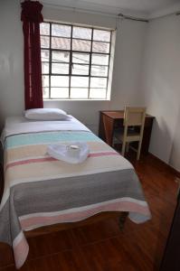 een bed in een kamer met een tafel en een raam bij Hostal Johumaji in Chachapoyas