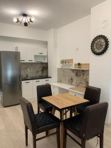 cocina con mesa, sillas y nevera en E&M Apartman, en Struga