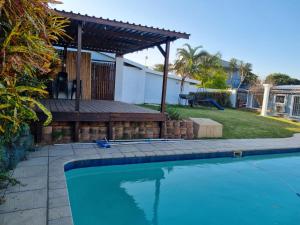 una piscina en un patio con pérgola en Troon Harmony - Room 1, en Durban