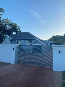 una valla con dos puertas delante de una casa en Troon Harmony - Room 1, en Durban