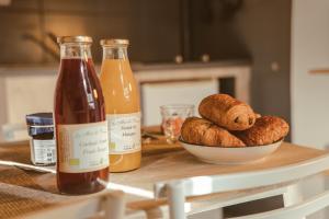 een tafel met een kom brood en een fles cider bij Appartement cosy idéal pour 2 personnes à Aubenas in Aubenas