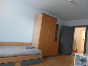 a bedroom with a bed and a wooden cabinet at Starling Loka in Škofja Loka