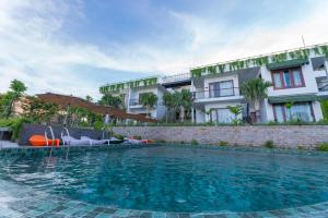 um hotel com piscina em frente a um edifício em Pandora Sand Hill Mũi Né Resort em Mui Ne