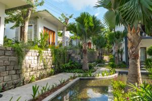 um jardim com piscina em frente a uma casa em Pandora Sand Hill Mũi Né Resort em Mui Ne