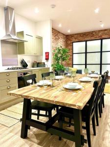 uma grande mesa de madeira numa cozinha com cadeiras em Brand New Apt - Beach Breeze Spacious 1-Bedroom Apartment with parking - sleeps 4 ppl- internet em Bournemouth