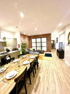 uma grande sala de jantar com uma mesa longa e cadeiras em Brand New Apt - Beach Breeze Spacious 1-Bedroom Apartment with parking - sleeps 4 ppl- internet em Bournemouth