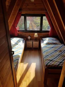 2 camas en una habitación pequeña con ventana en Nurdachhaus mit Kaminofen und großem Grundstück, en Faßberg