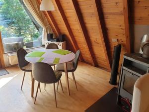 un comedor con mesa y sillas en una habitación en Nurdachhaus mit Kaminofen und großem Grundstück, en Faßberg