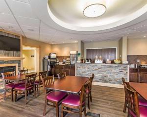 une salle à manger avec des tables et des chaises ainsi qu'une cuisine dans l'établissement Quality Inn, à Moncton