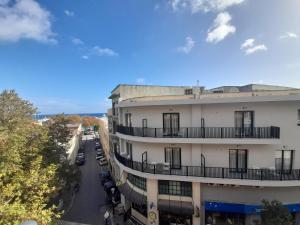 ein Apartmenthaus mit Autos, die auf einer Straße geparkt sind in der Unterkunft Elite Centre in Rhodos (Stadt)