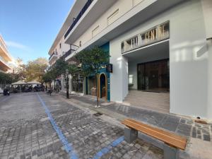 eine leere Straße mit einer Bank vor einem Gebäude in der Unterkunft Elite Centre in Rhodos (Stadt)