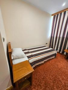 a small room with a bed and a window at Garni Hotel BaMBiS in Podgorica