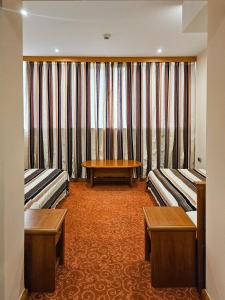 a hotel room with two beds and a table at Garni Hotel BaMBiS in Podgorica