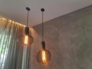 duas luzes penduradas numa parede com uma janela em Steindl's Boutique Hotel em Vipiteno