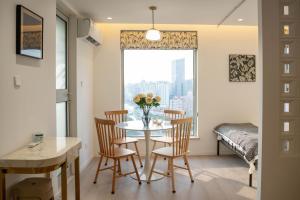 a dining room with a table and chairs and a window at Shanghai Yi Du B&B - Near Nanjing West Road commercial district, 350 walk from the Natural History Museum subway in Shanghai