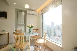 a dining room with a table and chairs and a large window at Shanghai Yi Du B&B - Near Nanjing West Road commercial district, 350 walk from the Natural History Museum subway in Shanghai