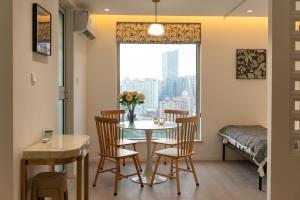 a dining room with a table and chairs and a window at Shanghai Yi Du B&B - Near Nanjing West Road commercial district, 350 walk from the Natural History Museum subway in Shanghai