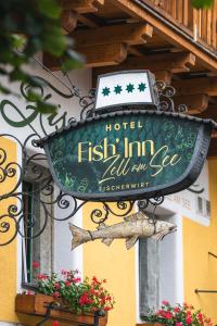 een bord op de zijkant van een hotel vis innulumulum bij Fish'Inn Zell - Hotel Fischerwirt in Zell am See