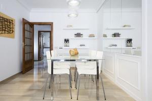 una cucina bianca con tavolo e sedie bianche di Stay U-nique House Torre Damians a Barcellona