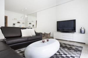 un soggiorno con divano e TV di Stay U-nique House Torre Damians a Barcellona