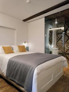 a bedroom with a large bed and a glass wall at DOMI Suites & Studios in Guimarães