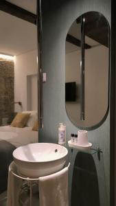 a bathroom with a sink and a mirror at DOMI Suites & Studios in Guimarães