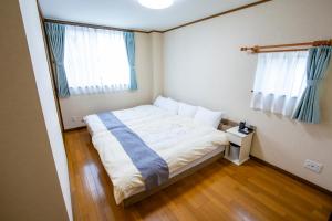 No1 Private Hotel&Villa Aomoril 186平米貸切 最大12名 في أوموري: غرفة نوم صغيرة بها سرير ونوافذ