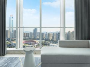 - un salon doté d'une grande fenêtre offrant une vue sur la ville dans l'établissement Sheraton Guangzhou Hotel, à Canton