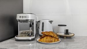 - un comptoir avec une cafetière et un plateau de croissants dans l'établissement Crackers, à Coffs Harbour