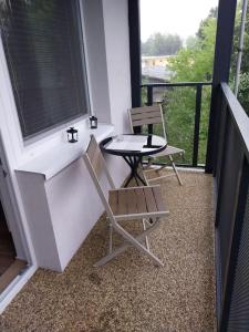 a balcony with two chairs and a table and a window at Krásny apartmán v centre Rožňavy in Rožňava