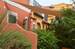 un edificio con un banco frente a algunas plantas en Le Mouillage, en Saint-Tropez