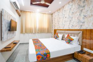 FabHotel Platinum Palace - Nr Magadi Main Road في بانغالور: غرفة فندق بسرير وتلفزيون