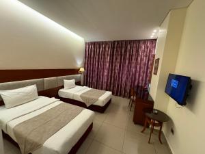 ein Hotelzimmer mit 2 Betten und einem TV in der Unterkunft Duroy Hotel By Beverly in Beirut