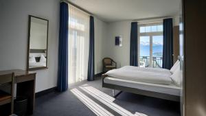 - une chambre avec un lit, un miroir et une fenêtre dans l'établissement Hotel Royal Luzern, à Lucerne