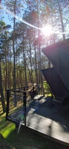 a deck with a table and a chair on it at FLY House Łeba in Łeba