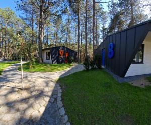 two black and white houses in the woods at FLY House Łeba in Łeba