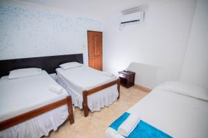 une chambre d'hôtel avec 2 lits et une table de nuit dans l'établissement Hotel Marie Real Cartagena, à Carthagène des Indes