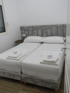 a bed with white sheets and pillows on it at DEJA BLUE Cozy Apartments in Durrës