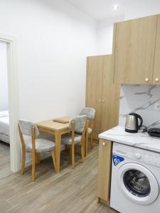 a kitchen with a table and a washing machine at DEJA BLUE Cozy Apartments in Durrës