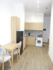 a kitchen with a table and a washing machine at DEJA BLUE Cozy Apartments in Durrës